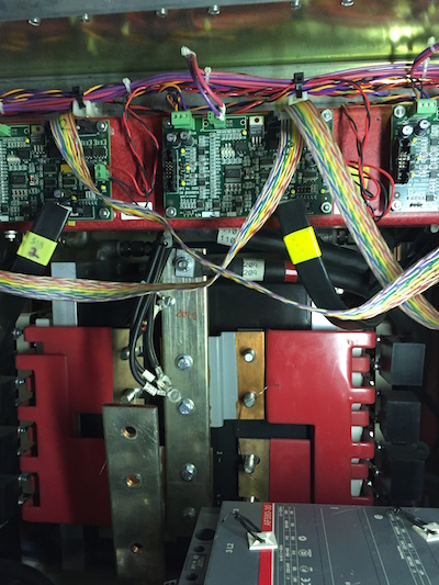 View of the IGBT switching circuit inside the power supply. The IGBTs and the high-frequency capacitors are mounted behind the red insulated bus work.