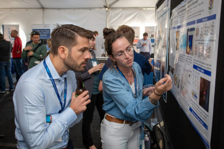 Photo of researchers discussing scientific poster.