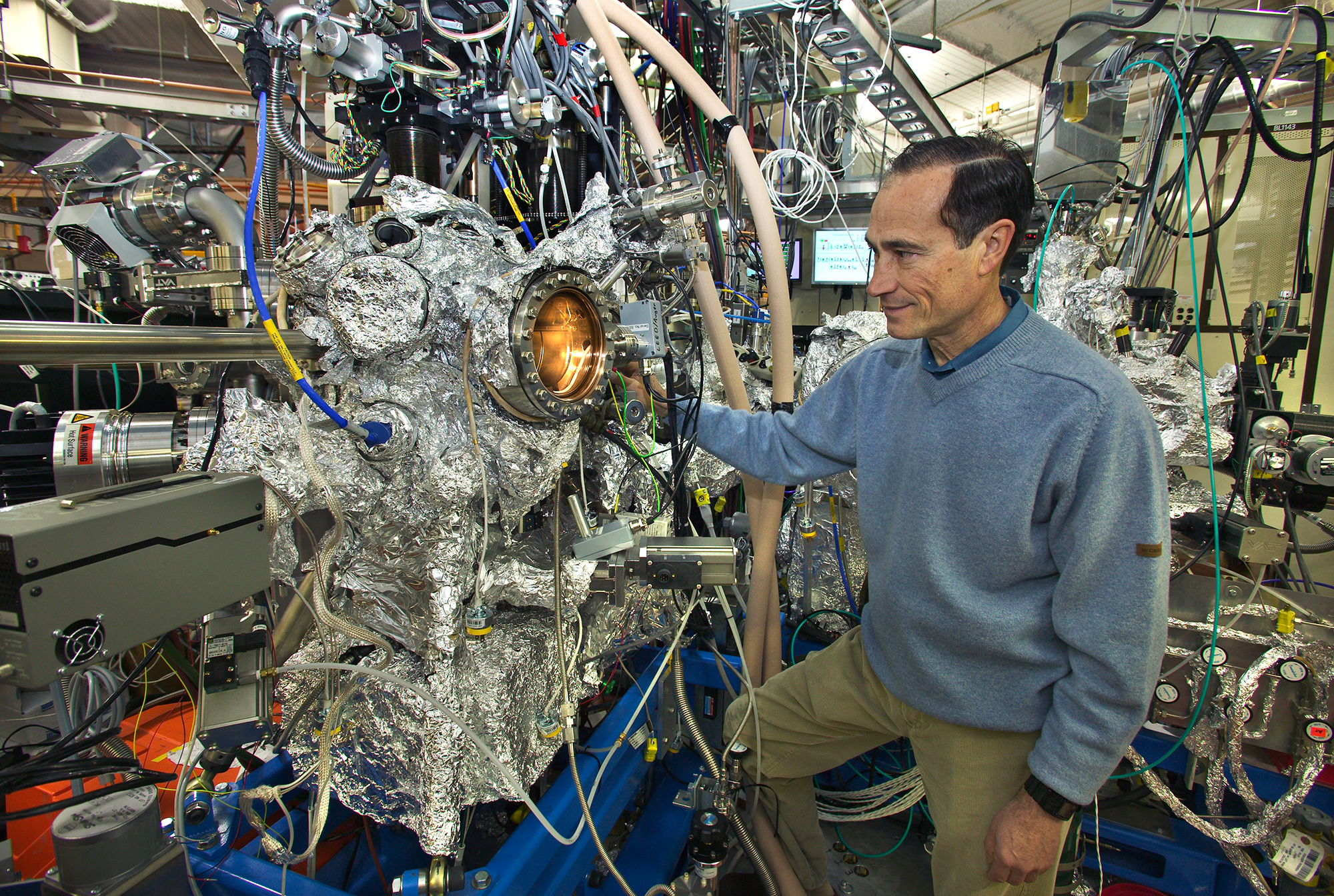 Photo of Miquel Salmeron looking into a lighted port of the foil-covered apparatus.