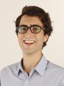 A young man with glasses, smiling