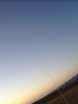 a kite flying in front of a sunset