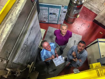 Looking down at three men in an industrial setting.