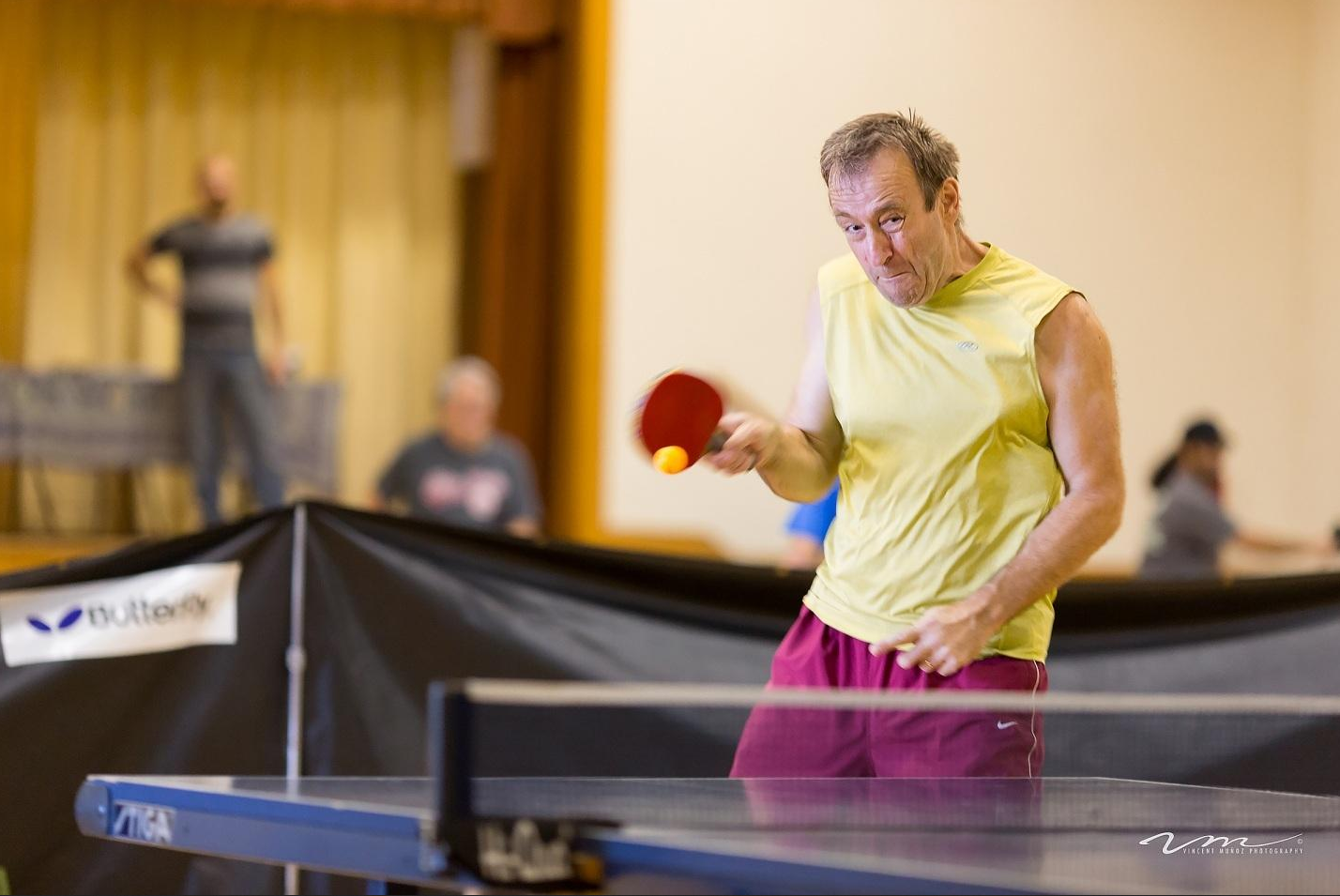 man wearing yellow shirt playing ping pong