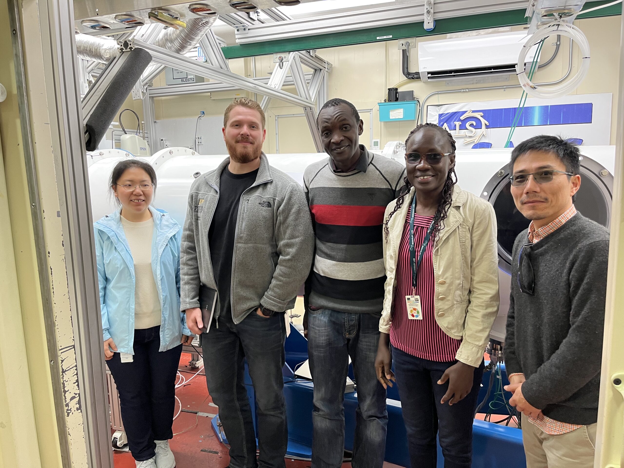 A group of five people stand in front of Beamline 7.3.3