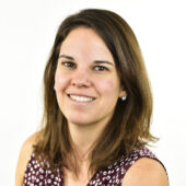 woman with brown hair wearing burgundy shirt with white dots