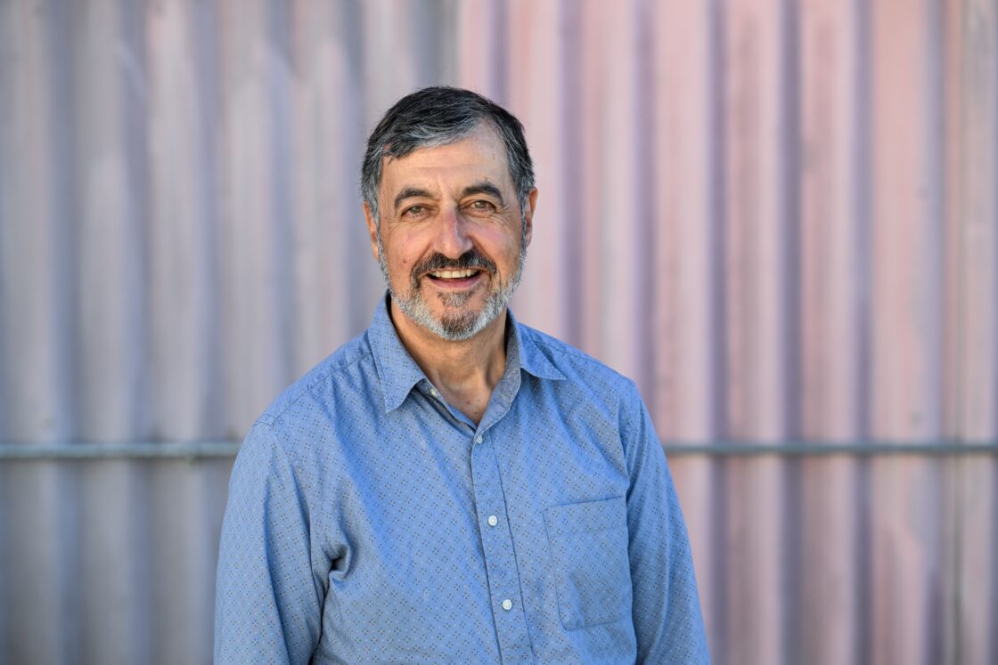 A man in a blue shirt, smiling.