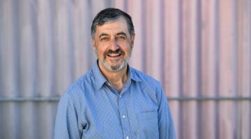 A man in a blue shirt, smiling.