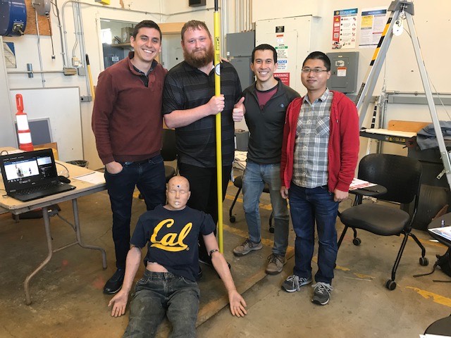 four men standing behind a mannequin