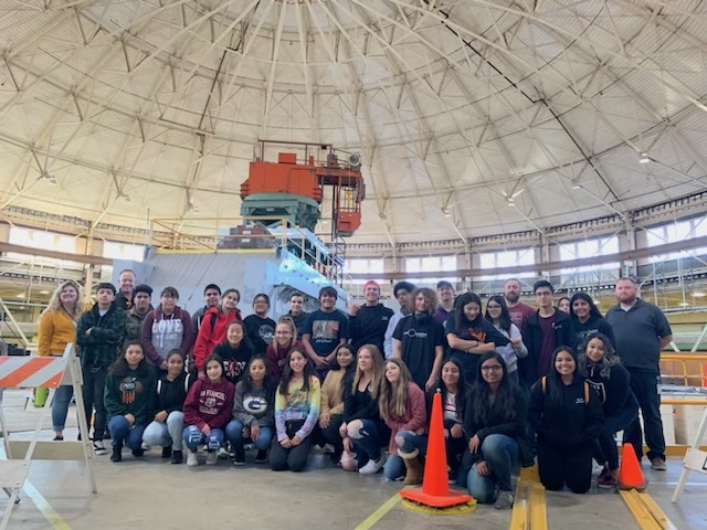 a group of people standing under a dome and orange crame