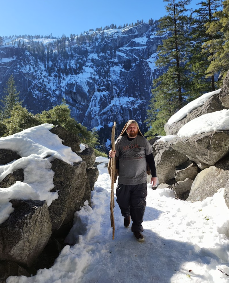 A man with a walking stick on a snowy mountain