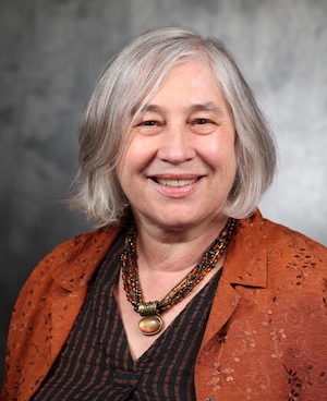 woman wearing necklace and orange blazer