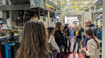 A group of people standing at a Beamline during an ALS tour.