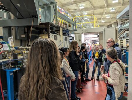 A group of people standing at a Beamline during an ALS tour.