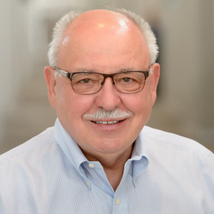 Man with black glasses and a collared shirt. 