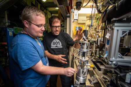 Two men working on a scientific instrument.