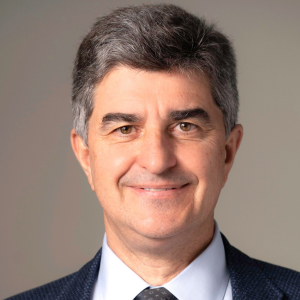 Man with dark hair, colored shirt and tie. 