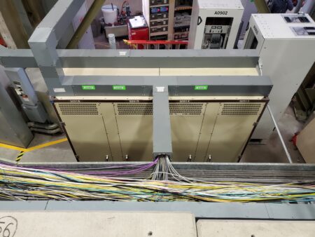 Electronic racks and in the foreground a cable tray with many, many cables of all kind of types and colors.