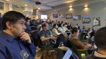 A large number of people sitting in an auditorium.
